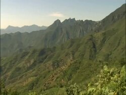 Pan right across from forested mountains to Great Wall of China, Mutianyu, China Stock Footage