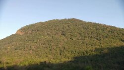 Shadows recede on a wooded hill; clouds cast shadows on the hillside. Stock Footage