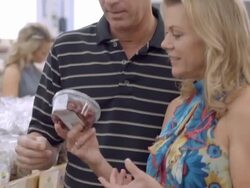 MS PAN middle-aged couple picks a tub of chocolate cherries from grocery shelf while a young couple on the other side of shelf examines bag of dried fruit / Cabazon, California, USA Stock Footage