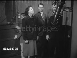 1953: GEORGETOWN UNIVERSITY: HEYDEN OBSERVATORY: VS Director Father Francis J. Heyden opening trap door, students following up stairs, gathering around telescope, SOT talking about size, larger than Galileo's, MS Grad students looking up, dome opening. Instructional Video