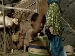Ethiopian boy cracks whip at camel market Stock Footage