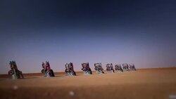 Wide shot of graffiti painted Cadillac's sticking out of the ground at Cadillac Ranch Stock Footage