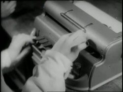 Hands type on a Braille typewriter. News Clip