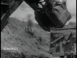 1941: AUSTRALIAN MINING: Explosion blast on side of open pit mine w/ mining equipment FG. SHIPPING MINED ORE: Ore crane filling open freight cars. Freight cars moving slowly on tracks. WWII Instructional Video