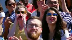 MS Smiling couple cheering and clapping with crowd during sporting event Stock Footage