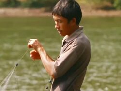 MS PAN SLO MO Shot of man pulling fishing net out of water / Ou river, Luang Prabang, Laos Stock Footage
