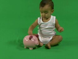 LS Baby putting coins into a piggy bank Stock Footage