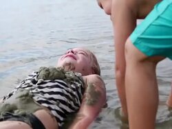 MS Shot of two young friends putting sand on each other at beach / St. Simons Island, Georgia, United States Stock Footage