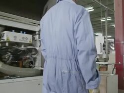 TS man walking along machine in furniture factory, stopping at control panel and inputting commands Stock Footage