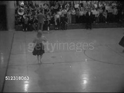 1952: ELKHORN HIGH SCHOOL BASKETBALL GAME: MS Athletics poster, 'Basketball, Kinne Gym...' VS Cheerleaders & band performing, female cheerleaders in seats singing & swaying, rallying crowd sitting in stands. (versus Milton-Union high), WI Instructional Video