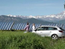 Couple leave car in green field beside solar cell plant Stock Footage