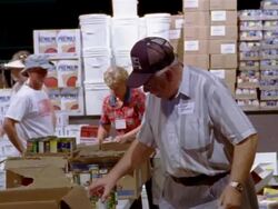 September 2005 Medium shot zoom in Senior man sorting canned goods inside Hurricane Katrina relief center / Mississippi Stock Footage