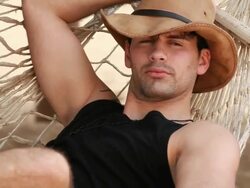 Good looking young man in hammock, smiles and waves at camera Stock Footage