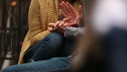 New York couple clasp hands on stoop of brownstone apartment, people cross in foreground (dolly-shot) Stock Footage