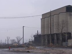 WS Tall concrete coal silos at an old power plant are demolished in controlled implosion using explosives / Weirton, West Virginia, USA Stock Footage
