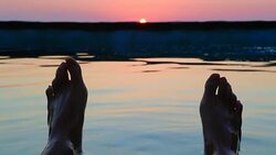 Guy from personal perspective swimming in a natural pool in the Mediterranean Sea Costa Brava recording his feet with the sunrise on the background in a stunning outdoor with great colors. Stock Footage