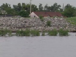 A stone levee holds the river back from neighborhoods in New Orleans. Stock Footage