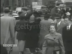 1951: LARGE CITY STREET SCENE: Crowd of people in spring or fall coats walking on 'big' city sidewalk w/ traffic moving BG. WS People walking on urban sidewalk, men in top coats over suits, women in short & long coats. Instructional Video