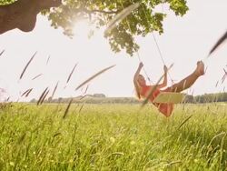 SLO MO Girl swinging in the meadow Stock Footage