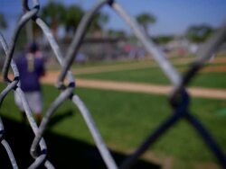 BASEBALL GAME BACKGROUND THRU FENCE Stock Footage