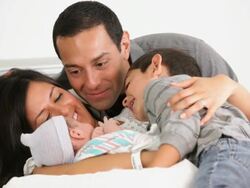MS PAN Mother, Father, and Young Son with Newborn Laying in Hospital Bed / Richmond, Virginia, USA Stock Footage