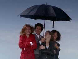 Medium shot businessman smiling and sheltering women from rain with umbrella Stock Footage