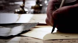 A hand writes with a pen on paper, moving from left to right. Stock Footage