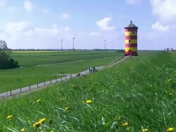 WS People enjoing at Pilsum lighthouse and wind mills near Krummhorn at North Sea (Eastern Friesland) / Lower Saxony Stock Footage