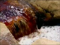 Mini waterfall stained red by mineral ores (iron & other minerals very high pH), Rio Tinto, Huelva, Andalusia, Spain Stock Footage
