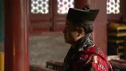 A man wears a cap and a colorful robe as he chants in the Baiyun Guan. Stock Footage