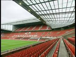 Manchester, Old Trafford; within ground children being given talk in stands, pan across pitch and interior of visitors centre. 2004; short sequence. Stock Footage
