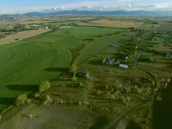 Low altitude aerial of farm fields and crops in the outskirts of Bozeman, MT Stock Footage