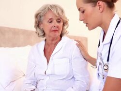 Home nurse speaking with elderly patient Stock Footage