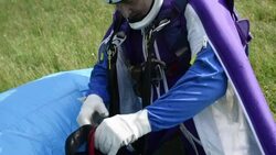 Portrait of BASE jumper after successful landing in field Stock Footage