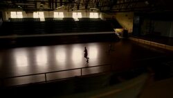 A basketball player makes a jump shot against a defender after both players jog onto a darkened court. Stock Footage
