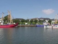 WS View of boats on old harbor with one ferry passing away, North Sea, North Frisia / Busum, Schleswig Holstein, Germany Stock Footage