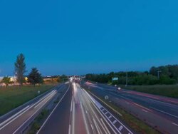 Time Lapse day to night tracking shot of freeway under a bridge Stock Footage