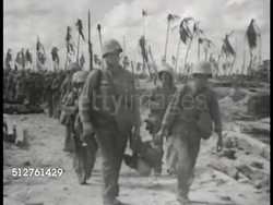 1943: BETIO, TARAWA: US Marines walking in line on beach, MS Marine's walking legs. (focus slightly soft) World War II. WWII. Instructional Video
