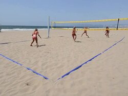 WS Establishing master shot of female beach volleyball players, showing the whole court,  serving and playing. Stock Footage