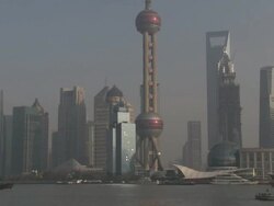 Ships and barges sail through downtown Shanghai past the famous skyline of Pudong, China Stock Footage