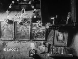 1949: INDIA CASTE SYSTEM: OUTCASTS / UNTOUCHABLES: VS Tagador & wife (Converts from Hindu to Christianity) praying in one room hut in front of religious icons, drawings, candles, VS Children sleeping.     Religion, religious, faith, converted, poverty. Instructional Video