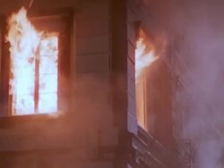 MS TU Blazing fire at building and fire fighter putting water / Unspecified Stock Footage