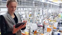 Beautiful businesswoman working on tablet in futuristic factory Stock Footage