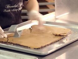 MS TU slab of hard toffee pressed out of baking tray and broken into smaller pieces with tenderizer hammer / Rancho Mirage, California, USA Stock Footage