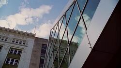 Architectural detail with modern glass windows contrasted with early 20th century stone building. Stock Footage