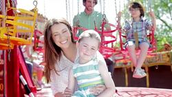 Mother and daughter sitting on amusement park ride Stock Footage