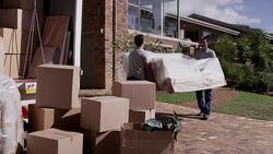 Men moving sofa from moving truck to house Stock Footage