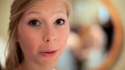 HANDHELD CLOSE UP nervous young bride turns to camera, letting out breath, and smiles before wedding Stock Footage