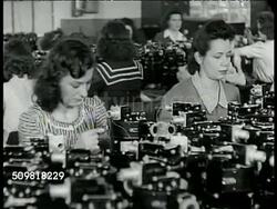 1944: JONES & LAMSON MACHINE CO.: VS Male factory workers operating machines. VS Female factory workers working w/ machines. VS Elder man at tool checking counter. VS Workers w/ saw machine. Springfield, Vermont. Instructional Video