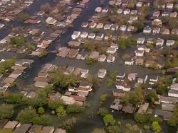 Aerial wide shot flooded Gentilly subdivision / zoom in rescuers in inflatable dinghy  / New Orleans, low angle Stock Footage